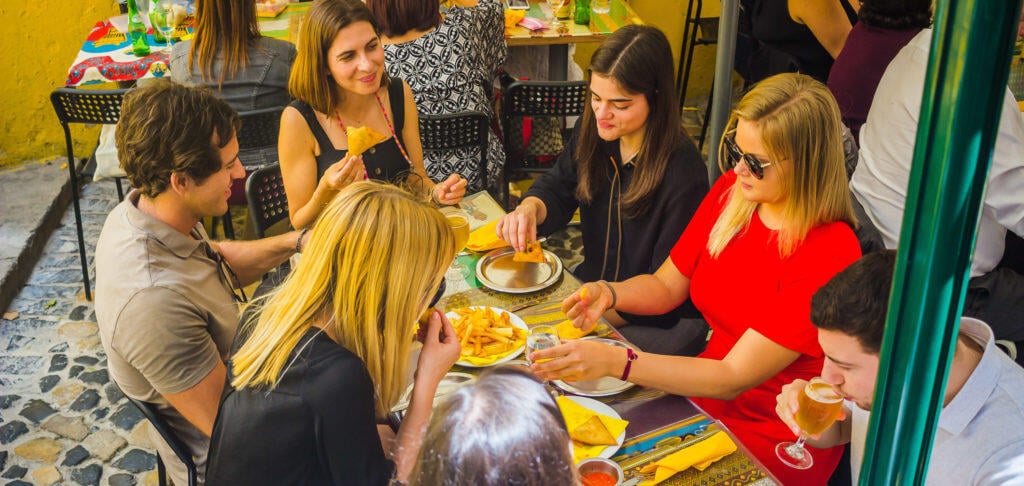 Group eating at a colorful table in Lisbon