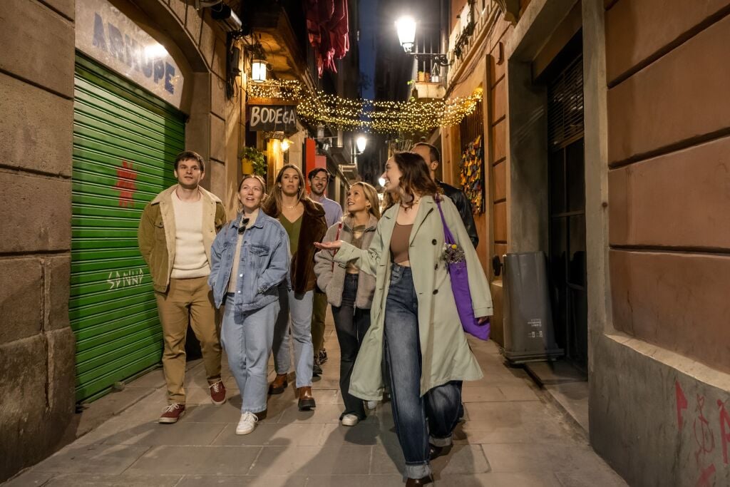 Guide walking outside with guests in the evening in Barcelona's side streets